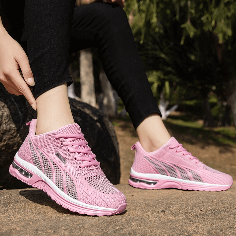 Light pink mesh lace-up women's sneakers SF1414 with cushioning insole, worn outdoors by an active woman, showcasing flexible elegance.